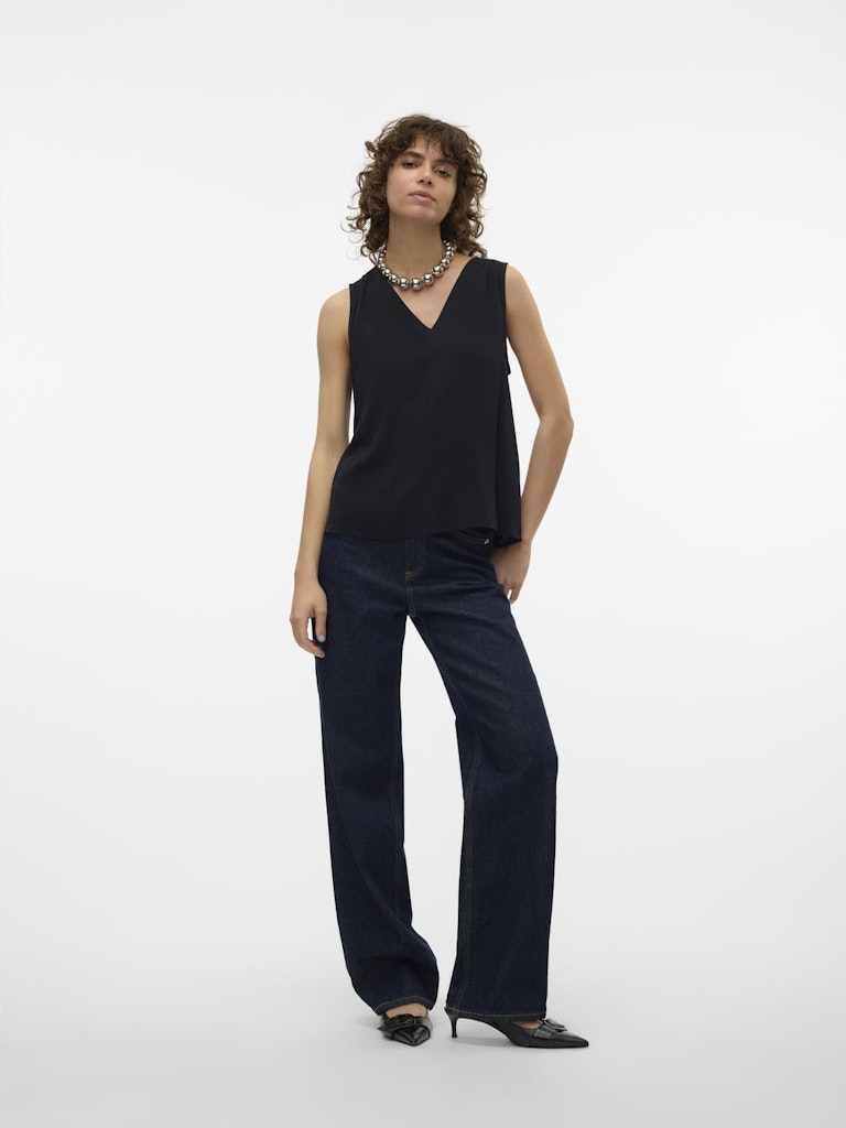 Μοντέλο φοράει τη μαύρη αμάνικη VERO MODA γυναικεία μπλούζα με τζιν για casual look
