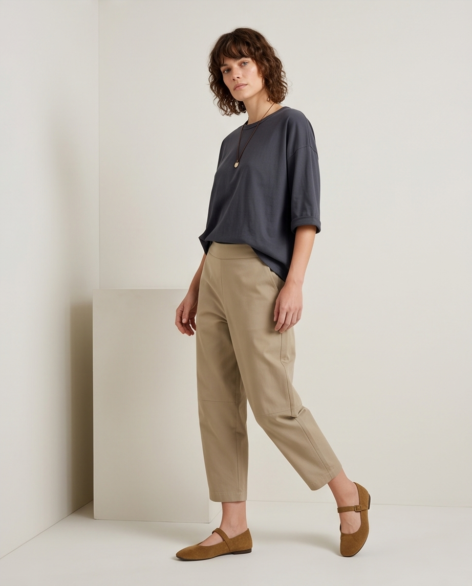 Γυναικεία ανθρακί oversized μπλούζα με στρογγυλή λαιμόκοψη, ολόσωμη πλάγια εμφάνιση με μπεζ παντελόνι
