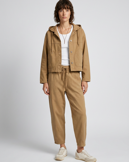 Γυναικεία camel ζακέτα με κουκούλα και κουμπιά, ολόσωμη εμφάνιση με λευκό top, camel παντελόνι και εκρού sneakers
