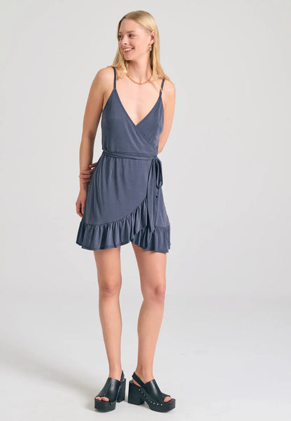 Μοντέλο αναδεικνύει το εντυπωσιακό FUNKY BUDDHA mini κρουαζέ φόρεμα με χαμηλό V λαιμό indigo