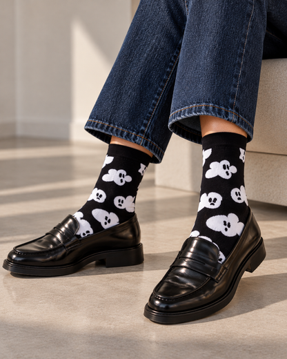 Happy Socks γυναικείες μαύρες κάλτσες Cloudy Ghost με λευκά φαντασματάκια που θυμίζουν συννεφάκια, φορεμένες.
