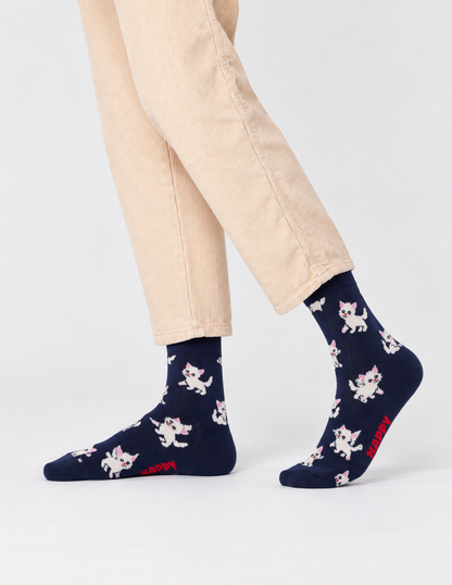 Happy Socks γυναικείες σκούρες μπλε κάλτσες Kitten με λευκά γατάκια, ροζ λεπτομέρειες και κόκκινο λογότυπο, φορεμένες.
