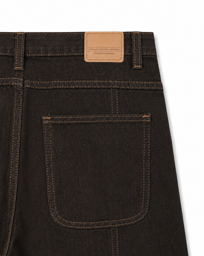 Κοντινό detail πίσω τσέπης και δερμάτινης ετικέτας γυναικείου καφέ baggy jeans με χρυσές ραφές
