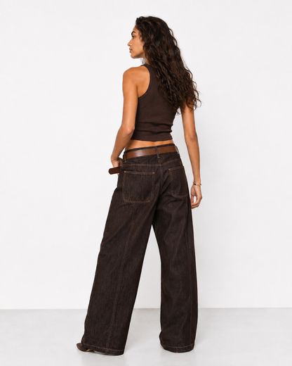 Γυναικείο καφέ baggy jeans με ψηλή μέση, μεγάλες πίσω τσέπες και καφέ δερμάτινη ζώνη, πίσω εμφάνιση με καφέ crop top και καφέ μποτάκια
