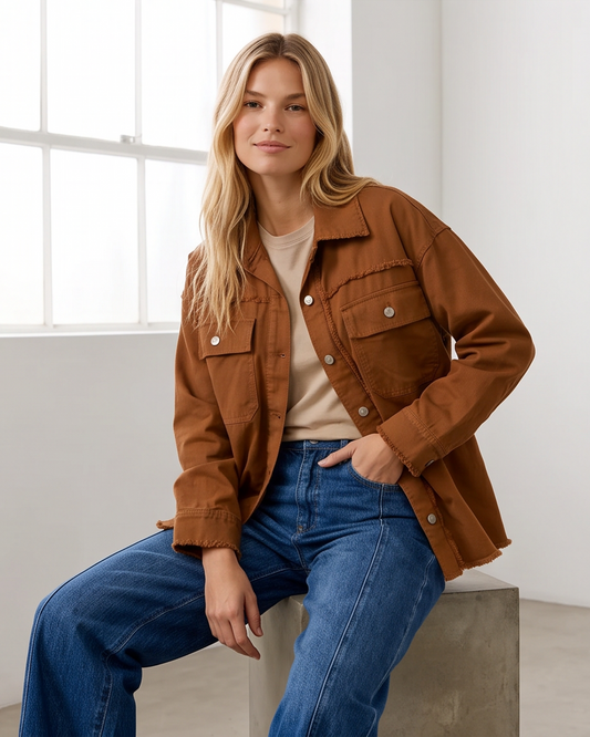 Γυναικείο κεραμιδί jacket πουκάμισο με τσέπες και ξέφτια, εμφάνιση καθιστή με μπλε τζιν σε φυσικό φωτισμό
