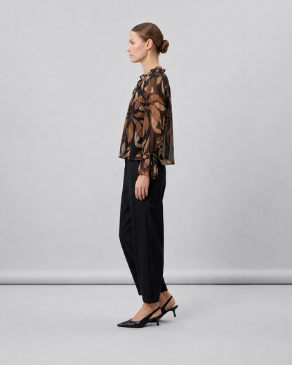 Γυναικεία μαύρη floral μπλούζα georgette με αέρινα μανίκια και σούρες, πλάγια εμφάνιση με μαύρο παντελόνι
