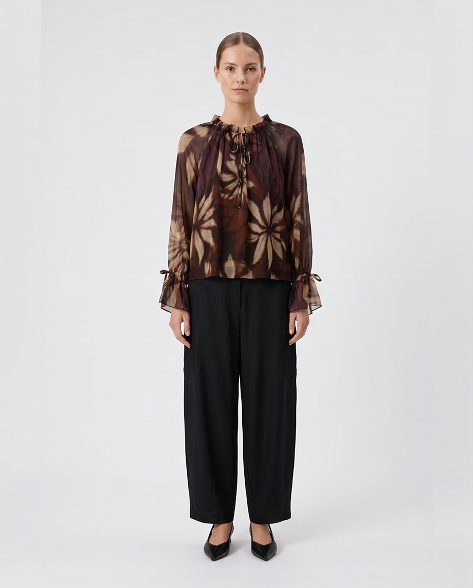 Γυναικεία μωβ floral μπλούζα georgette με σούρες και δεσίματα, ολόσωμη εμφάνιση με μαύρο παντελόνι
