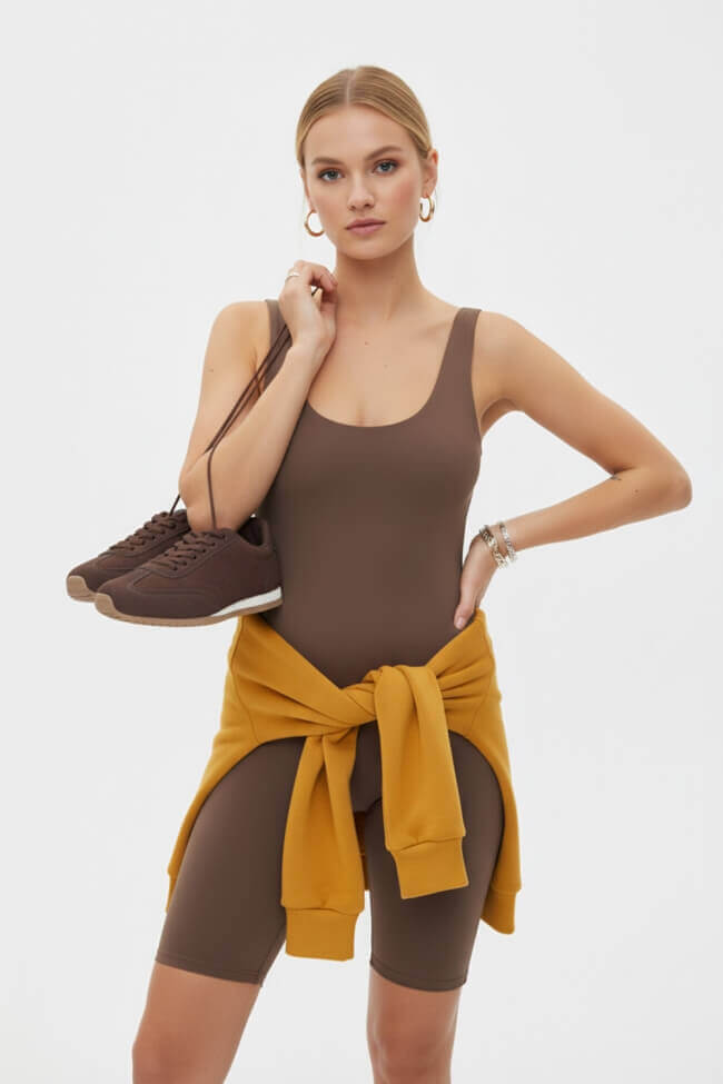 Γυναίκα με minimal sneakers καφέ - styling look με καφέ top και κίτρινο φούτερ