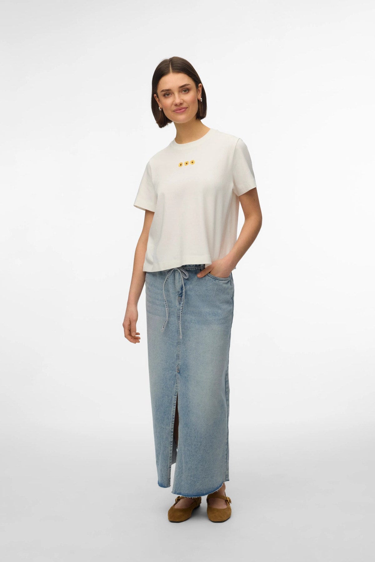 ALT TEXT:
λευκό t-shirt Vero Moda με sunflower print σε μοντέλο full body με denim maxi φούστα
