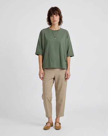 Γυναικεία χακί oversized μπλούζα με στρογγυλή λαιμόκοψη, ολόσωμη εμφάνιση με μπεζ παντελόνι
